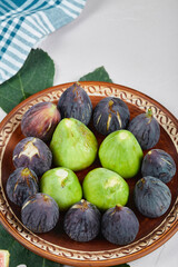 Green and black figs on a ceramic plate