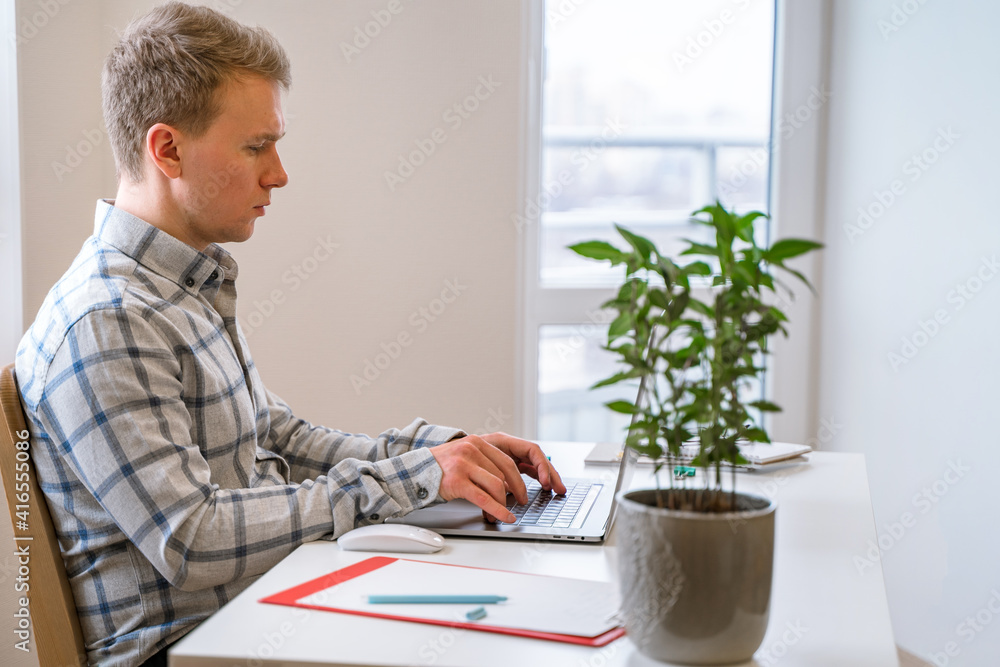 Poster handsome man working using computer laptop and drinking a mug of coffee with thinking serious face i