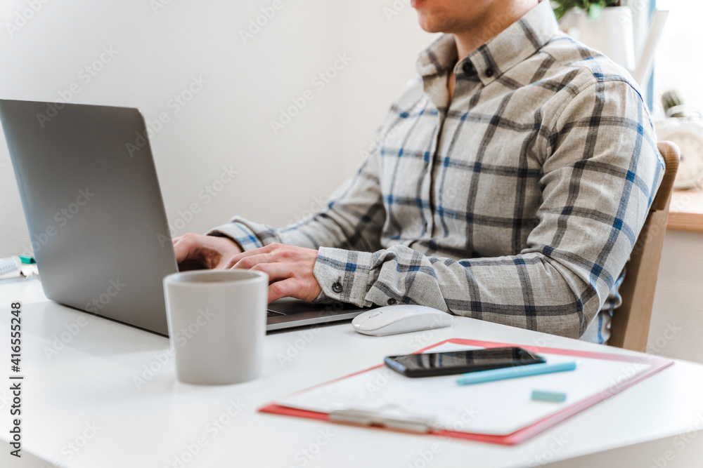 Canvas Prints handsome man working using computer laptop and drinking a mug of coffee with thinking serious face i