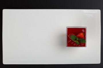 Panna cotta. Milk panna cotta with forest fruits. Panna cotta with different flavors, chocolate, smoothies, almond flakes. Panna cotta on a flat plate, on a white background.