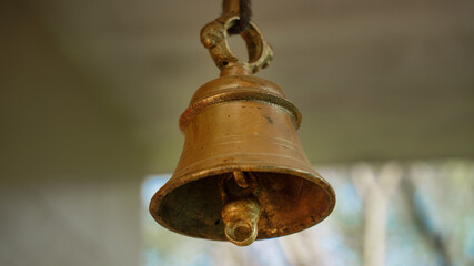 New bronze bell in indian temple with blur background.Close-up of Hindu temple brass bell hanging in gold color