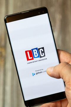 02-24-2021 Portsmouth, Hampshire, UK A mobile phone or cell phone being held by a hand with the LBC radio app open on screen
