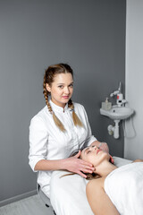 Facial massage of young woman receiving spa massage in beauty spa. Cosmetology.