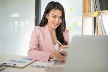 Portrait of Asian woman using computer laptop innovative ideas, in video call conference meetings and work from home.