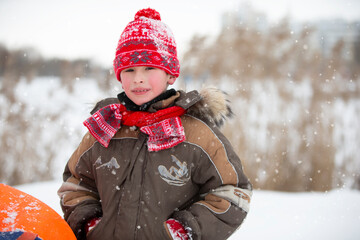 Children in winter. Cheerful boy in warm winter clothes.