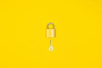 Lock and key on a yellow background.