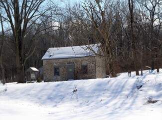 Fototapeta na wymiar The old stone building in the snowy park landscape.