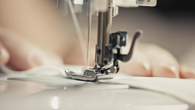 Person sewing clothes, extreme close-up. Tailoring, clothes design, seamstress. Operating sewing machine