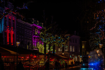 Fototapeta na wymiar Christmas city lights cozy street cafe scene. Beautiful sparkling and twinkling lights on a European Christmas Market. Winter holiday season.
