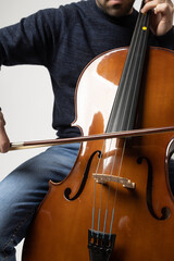 young man playing cello on the white background