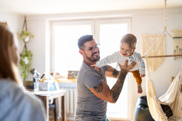 Father playing with his little son at home
