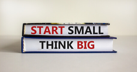 Obraz premium Start small think big symbol. Concept words 'Start small think big' on books on a beautiful white background. Business, motivational and start small think big concept.
