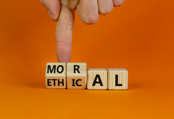 Ethical or moral symbol. Businessman turns wooden cubes and changes the word 'moral' to 'ethical'...