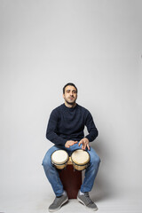 young man playing bongos on the white background