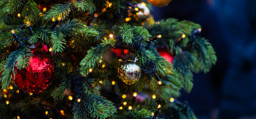 Decorated Christmas tree on blurred background. New Year's and Christmas holiday background with lights on tree.