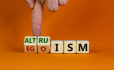 Altruism or egoism symbol. Businessman turns wooden cubes and changes the word 'egoism' to...