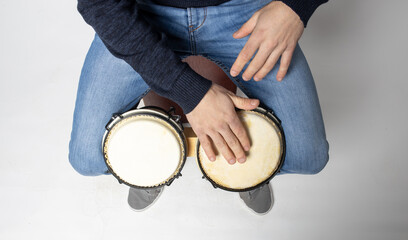 young man playing bongos on the white background