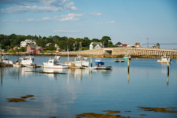 Fototapeta na wymiar Boats and warehouse on a dock on the Maine coast fishing port