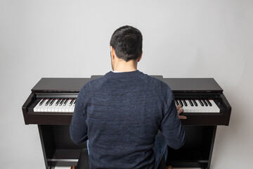 young man playing piano on the white background