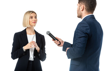 news anchor with microphone taking interview from young blonde businesswoman isolated on white