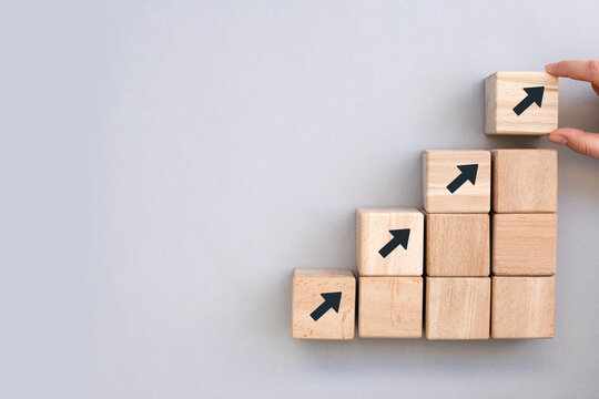 Business concept growth success process, Close up Woman hand arranging wood block stacking as step stair on grey background, copy space.