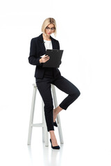 full length view of news anchor sitting on high stool with clipboard on white