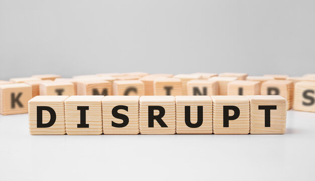 Word DISRUPT made with wood building blocks