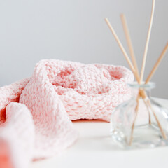 Fototapeta na wymiar aroma diffuser with sticks on white background with pink soft towel, spa and aromatherapy