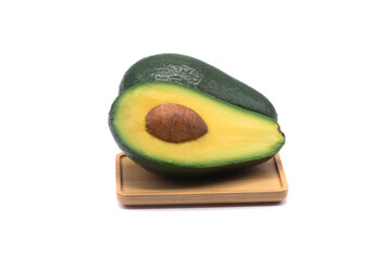 Avocado with a bone on a wooden stand on white background