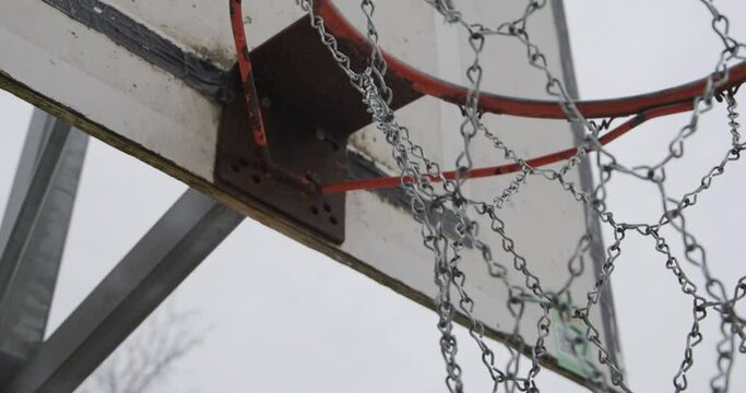 Metallic net of an old basketball hoop, handheld dramatic shot