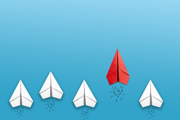Group of paper plane in one direction and one pointing in different way on blue background....