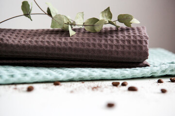 spa and relaxation towels, brown and green towels on a white background with a branch of eucalyptus