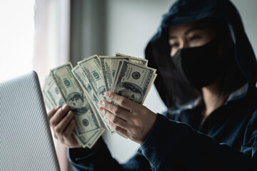 Woman dangerous Hooded Hacker held the money after successfully hacking.