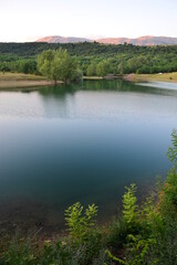 Fototapeta na wymiar Idyllischer See Perućko Jezero bei Sinj, Vrlika in Kroatien mit Bäumen und Berge im Hintergrund
