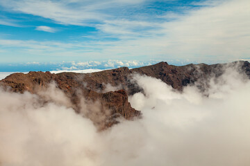 Fototapeta na wymiar Impressive landscape of clouds and volcanic mountains from the top of the Roque de los Muchachos viewpoint, on the island of La Palma, Canary Islands, Spain.