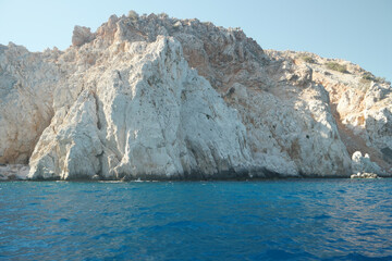 Fototapeta na wymiar Detail of the rocky coast and blue calm sea. Limestone rock in turquoise sea water.