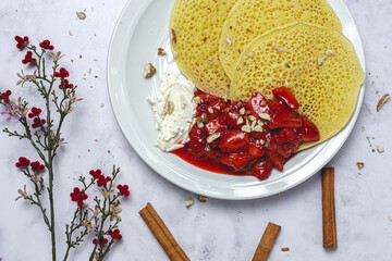 Homemade traditional moroccan baghrir with honey, strawberries and mint from above