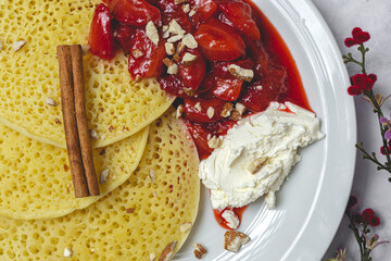 Homemade traditional moroccan baghrir with honey, strawberries and mint from above