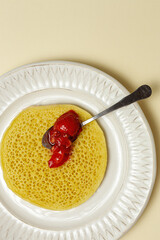 Homemade traditional moroccan baghrir with honey, strawberries and mint from above