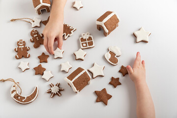 Children are getting ready for Christmas. Sugar glazed gingerbread cookies in children's hands. Top...