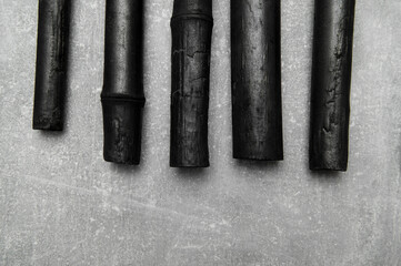 Natural activated bamboo charcoal on concrete background. Realistic pieces charcoal.