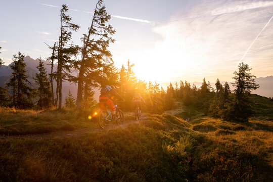 Two mountain bikers are doing off-road moutain biking early morning at sunrise.
