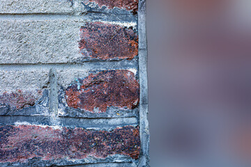 Dark cracked paint on a brick. Old brick gray wall and blurred gradient background. Soft focus. Copy space.