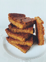 Stack of delicious freshly baked blondie brownie dessert slices, close up. Healthy vegan sugar free sweet bars. Vegetarian confection. Homemade pastry. Copy space.
