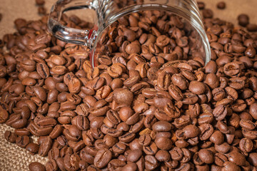 Roasted coffee beans on jute fabric with a Cup of coffee