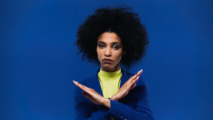 African american woman showing stop gesture isolated on blue
