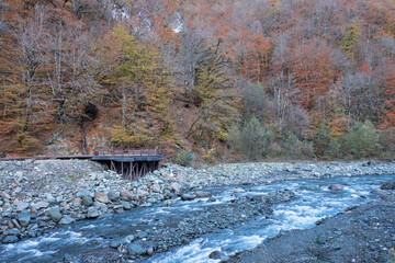 Rocky shore of the Mzymta River near Rosa Khutor Alpine Resort in Krasnodar Krai, Russia. Autumn landscape