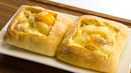 Baked Egg Ciabatta Boats. ciabatta with egg on a wooden plank 