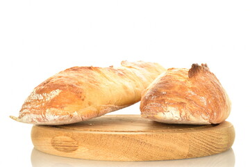 Two delicious freshly baked French baguettes on a round wooden tray, close-up, isolated on white.