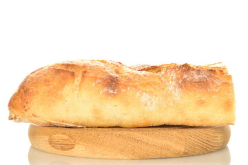 One half of delicious freshly baked French baguette on a round wooden tray, close-up, isolated on white.